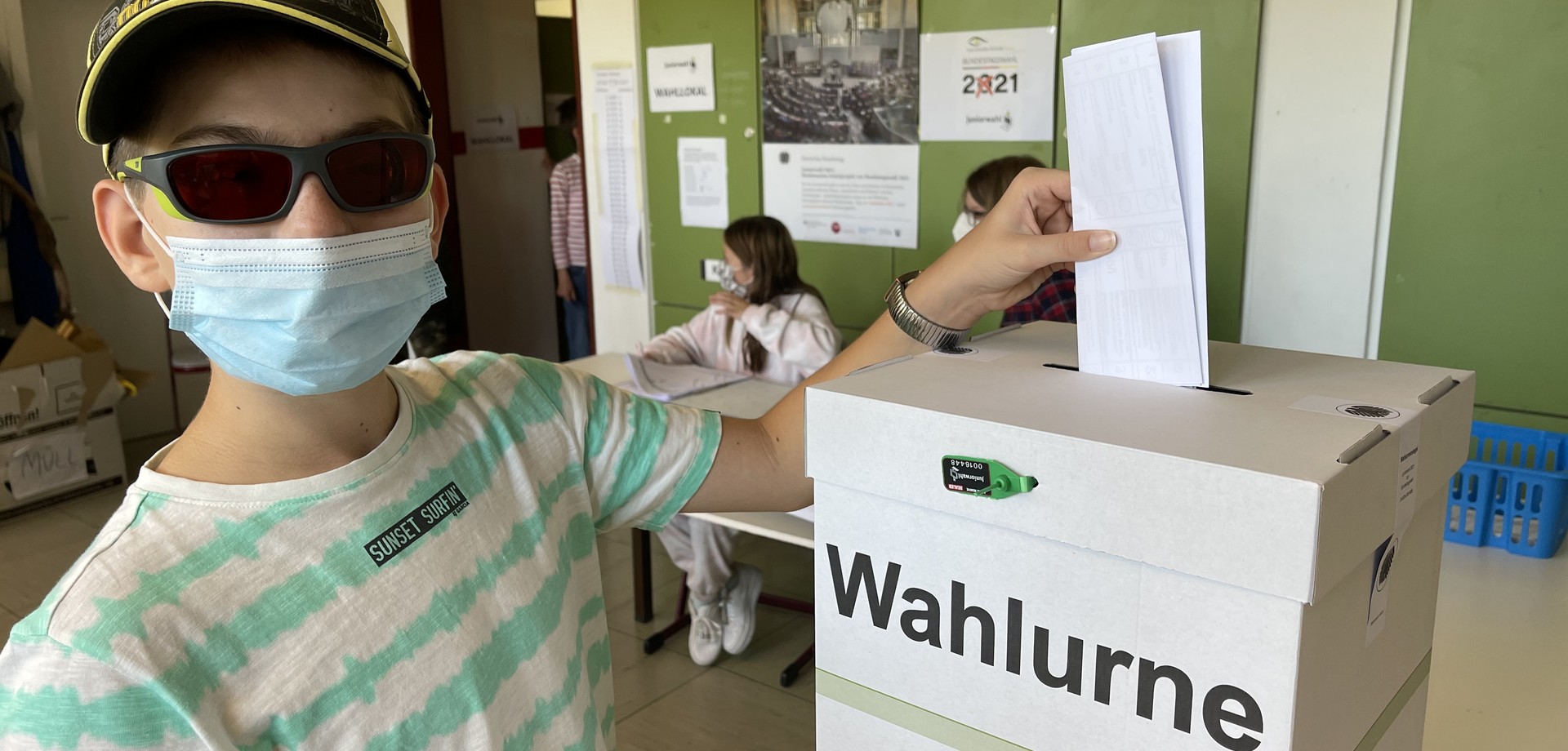 Ein Schüler wirft einen Wahlschein in die Wahlurne bei der Teilnahme an der Juniorwahl zur Bundestagswahl