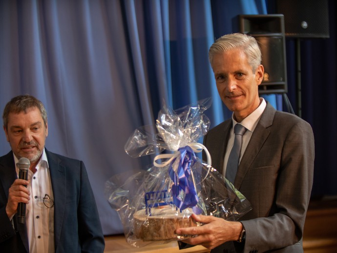 Andreas Liebald hält ein symbolisches Geschenk des LWL-BBW Soest in den Händen (öffnet vergrößerte Bildansicht)