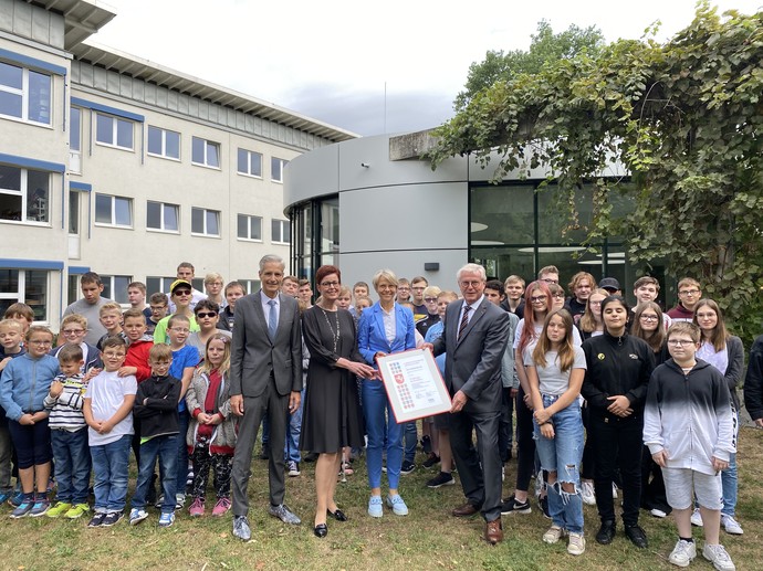 Gruppenbild mit Schülerinnen und Schülern sowie Andreas Liebald, Birgit Westers, Schulministerin Dorothee Feller und Klaus Baumann (v.l.n.r.)